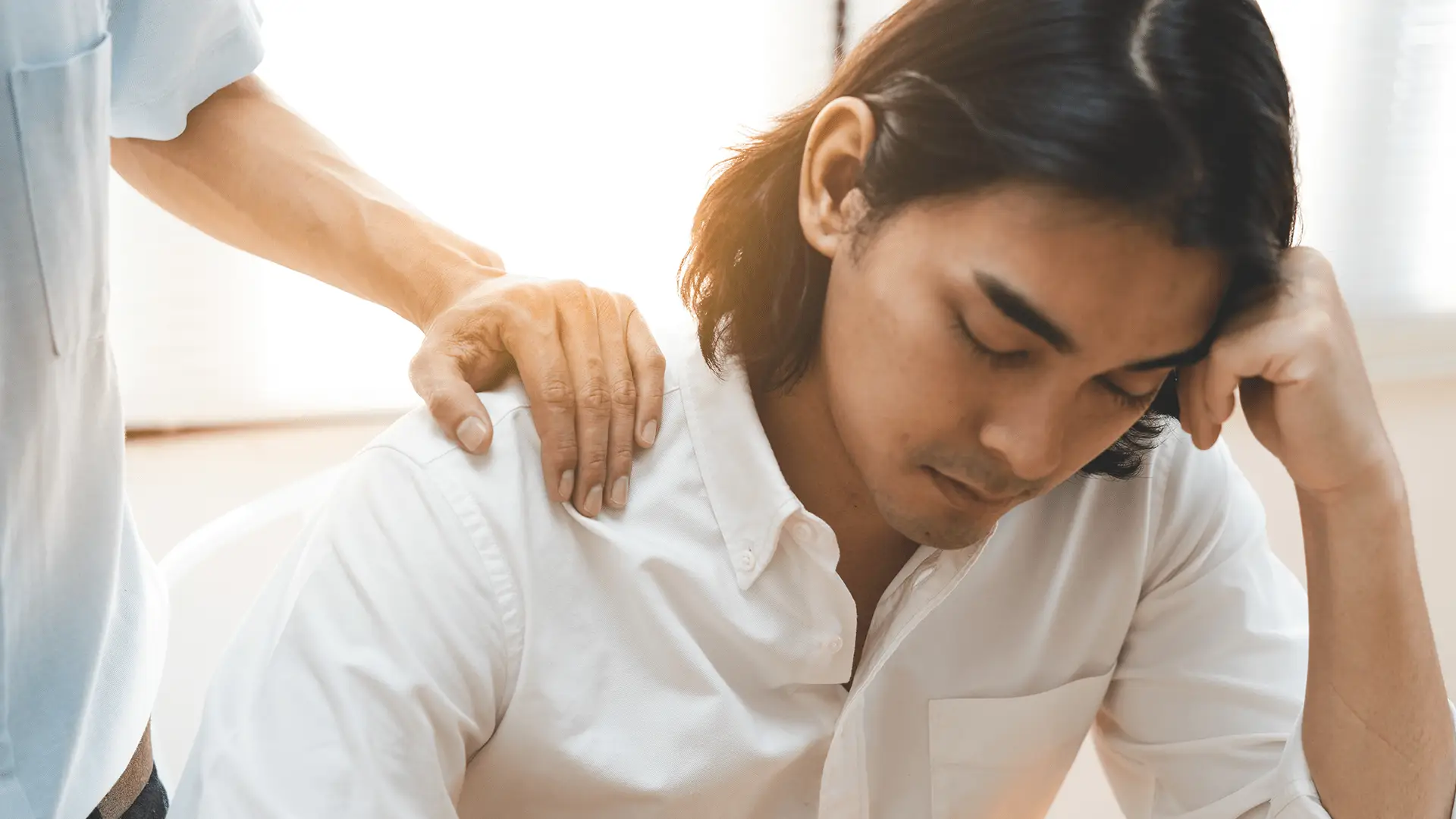 Man suffering depression being comforted by a friend