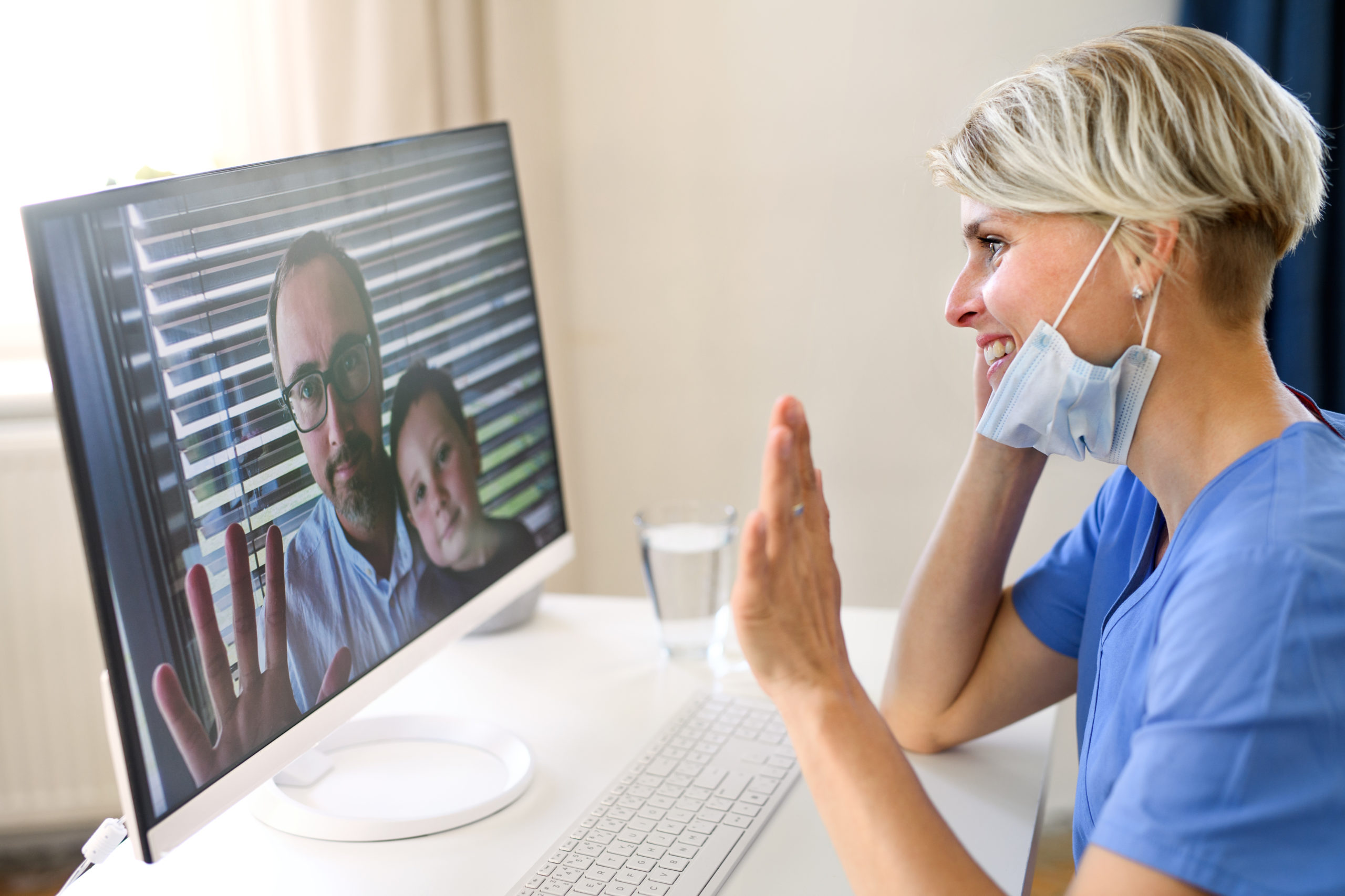 A healthcare professional in blue is engaging in an online therapy session with a patient and child, symbolizing the online therapy services available in Florida."