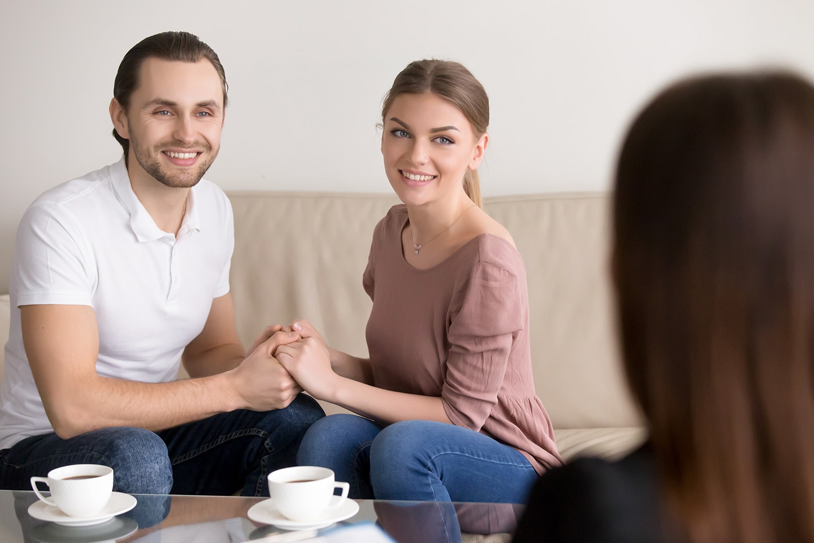A couples relationship counseling engaging in relationship counseling, sitting together and holding hands, with an attentive focus towards a counselor in Sarasota