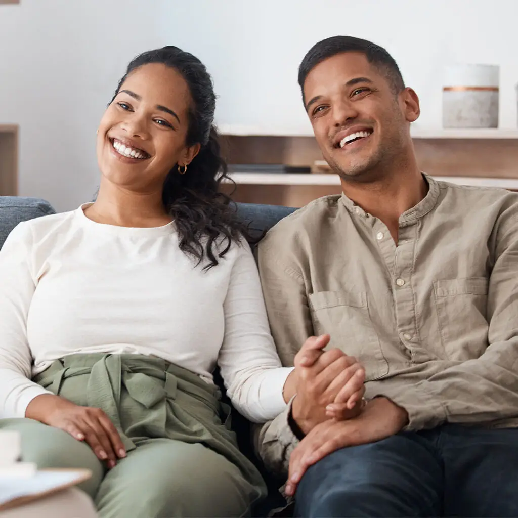 a happy couple sitting on a couch
