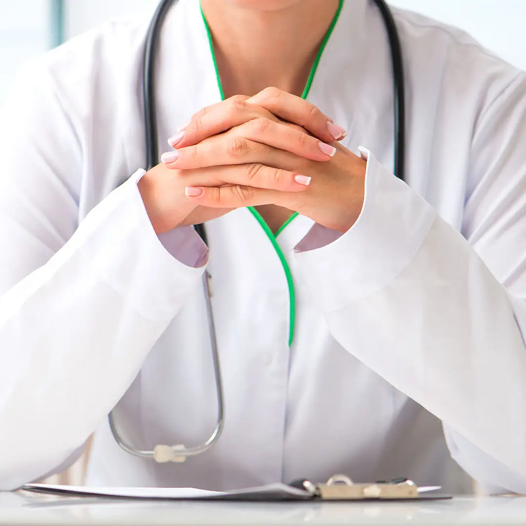 a close-up of a doctor's hands folded